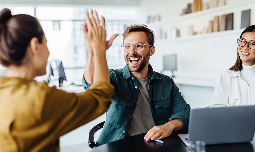 Happy people in an office giving a high five